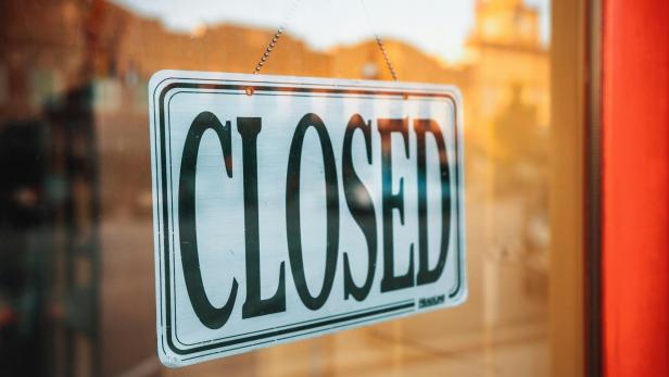 Ein Schild mit der Aufschrift "Closed" hängt im Schaufenster