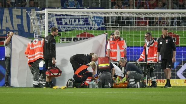 Sanitäter versorgen einen verletzten Spieler auf dem Fußballfeld während eines Bundesligaspiels zwischen Heidenheim und Bochum.