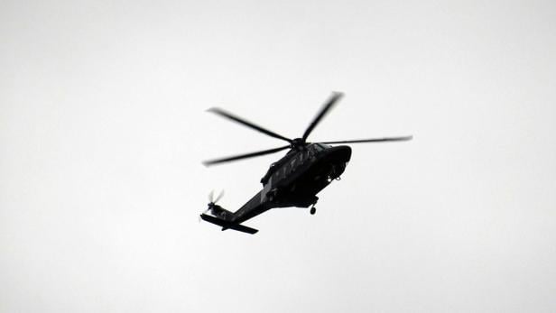 Hubschrauber am Himmel Schwarzer Hubschrauber am grauen Himmel