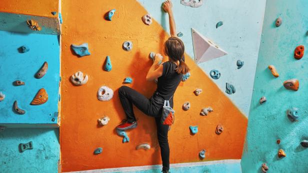 Woman climbing up on practice wall