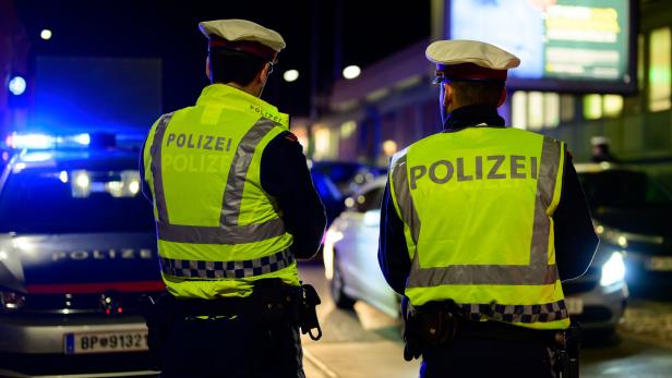 Polizisten vor Polizeiautos