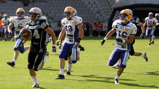 American-Football-Spieler laufen während eines Spiels über das Feld.