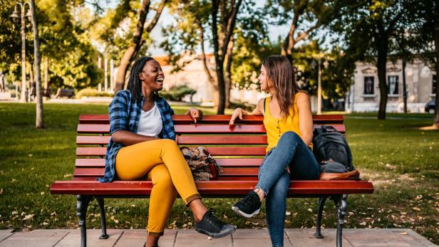 Friends talking on bench