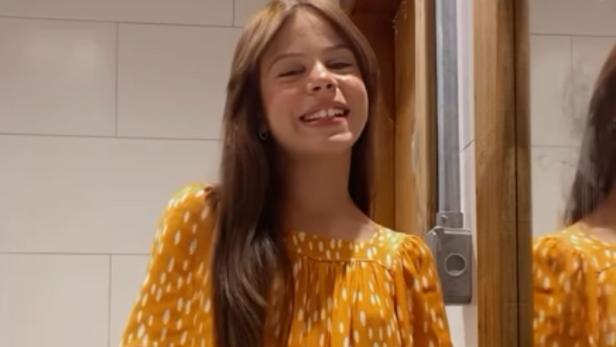 Millena Brandão Millena Brandão trägt ein gelbes Kleid mit weißen Tupfern und lacht in die Kamera