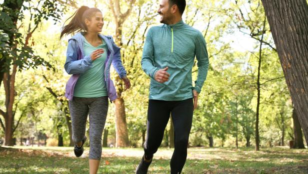 Young couple running together in park. Young people exercising. Young couple running together in park. Young people exercising.