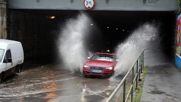 Auto im Tunnel, Gischt spritzt weg.