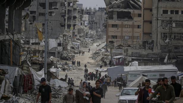 Internally displaced Palestinians move in the streets of Al Shejaeya neighbouhood in the east of Gaza City