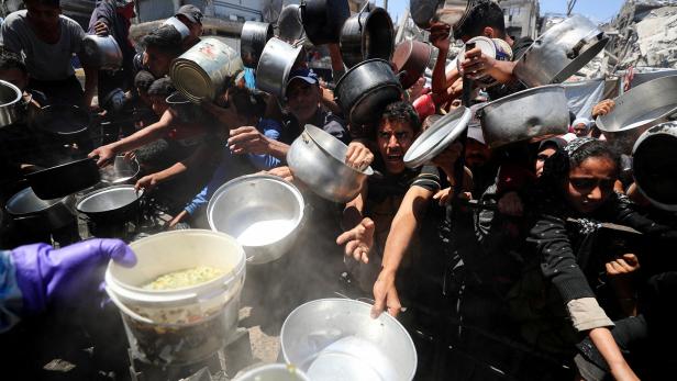 FILE PHOTO: Palestinians receive food cooked by a charity kitchen, in Beit Lahia Verzweifelter Kampf um ein wenig Essen im Gazastreifen