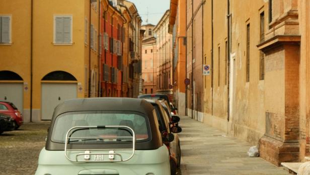Geparkte Autos in italienischer Gasse.