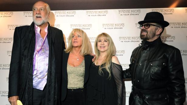 Eine Gruppe von vier Personen posiert vor einer Wand mit dem Schriftzug „Stevie Nicks in Your Dreams“.