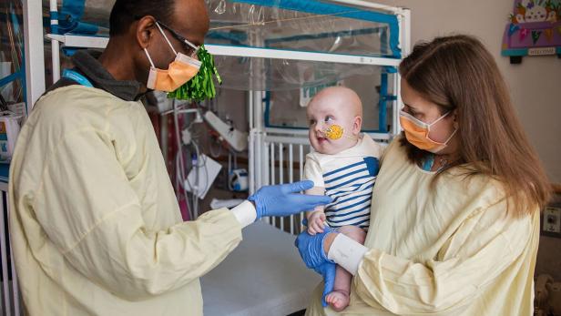 Das Bild zeigt Baby KJ mit dem Kardiologen Kiran Musunru und der Kindermedizinerin Rebecca Ahrens-Nicklas am Children's Hospital of Philadelphia.