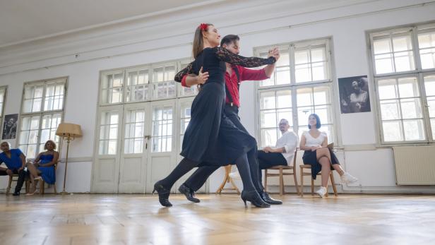 Elegant Caucasian Couple Dancing Gracefully in Bright Dance Studio with Wooden Floors Ein elegantes, kaukasisches Paar tanzt anmutig in einem hellen Tanzstudio mit Holzböden.
