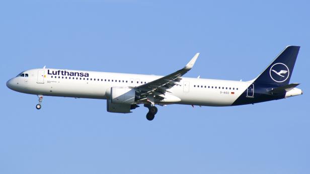 Ein Lufthansa Airbus A321neo im Flug vor blauem Himmel.
