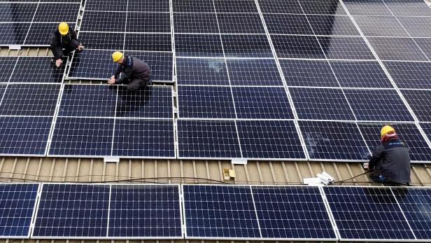 Workers install solar panels on an office building in Skopje Workers install solar panels on an office building in Skopje