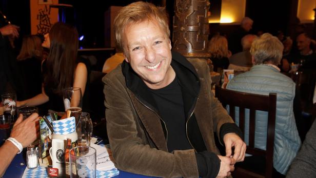 Max Müller sitzt an einem Tisch in einem Restaurant.