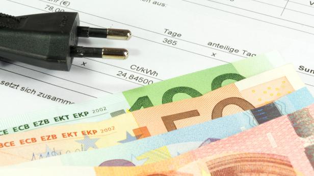 Euroscheine und Gerätestecker auf einer Stromrechnung