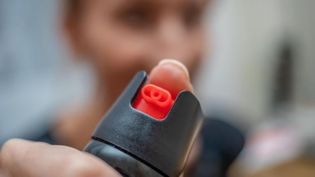 Close up of pepper spray in the girl's hand in the room