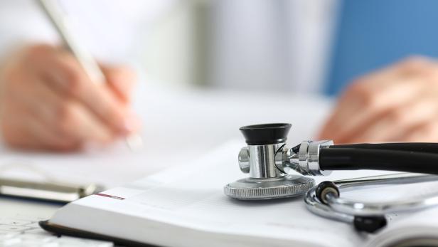 Stethoscope head lying on medical forms closeup