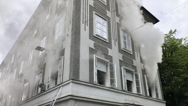 Feuerwehrleiter vor qualmendem Haus