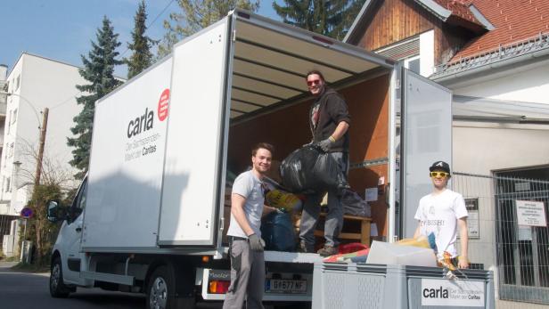 Männer beladen Lkw mit Sachspenden der Caritas