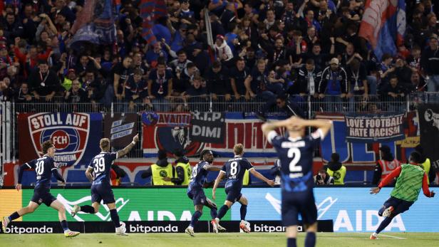 Fußballspieler von Heidenheim jubeln vor der Fankurve während eines Relegationsspiels.