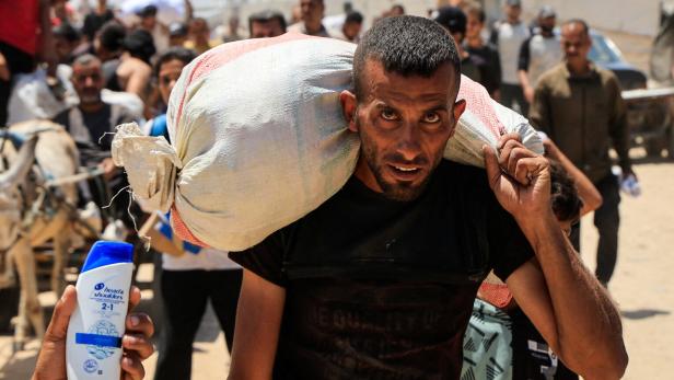 Palestinians carry aid supplies they received from the U.S.-backed Gaza Humanitarian Foundation, in Khan Younis Palestinians carry aid supplies they received from the U.S.-backed Gaza Humanitarian Foundation, in Khan Younis