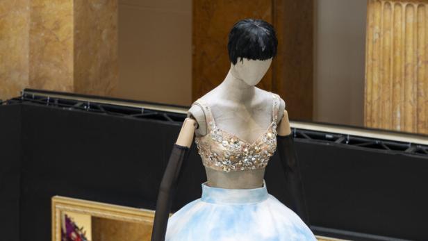 Eine Schaufensterpuppe trägt ein Kleid mit einer aufgemalten Darstellung des Kolosseums.