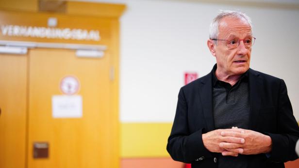 Peter Pilz steht vor einer Tür mit der Aufschrift „Verhandlungssaal“.