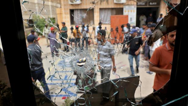 Members of media are seen through a broken glass window inside the premises of the district Malir jail after dozens of prisoners escaped from the jail on the outskirts of Karachi