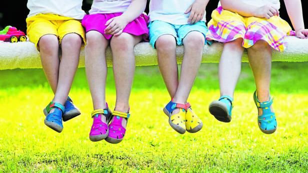 Kinderfüße mit bunten Schuhen.