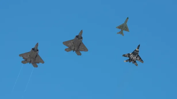2 F-22 neben einer MiG-21 und einer MiG-29 (r.).