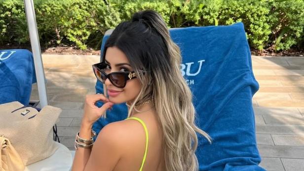 Die 35-jährige Influencerin Janaina Prazeres posiert mit Sonnenbrille auf einer Sonnenliege