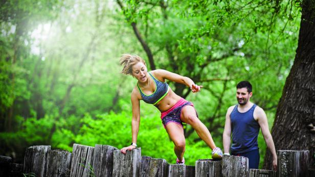 Ein Pärchen das gemeinsam durch den Park joggt