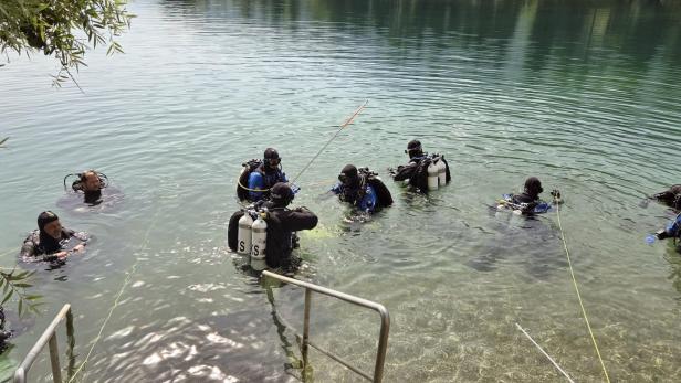 Eine Gruppe von Tauchern bereitet sich im flachen Wasser auf einen Tauchgang vor.