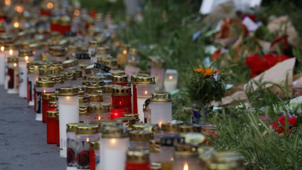Kerzen und Blumen vor Schule