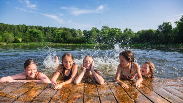 Happy children enjoying summer holidays at a lake