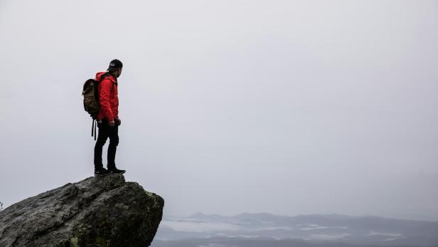 Wanderer steht auf Felsbrocken