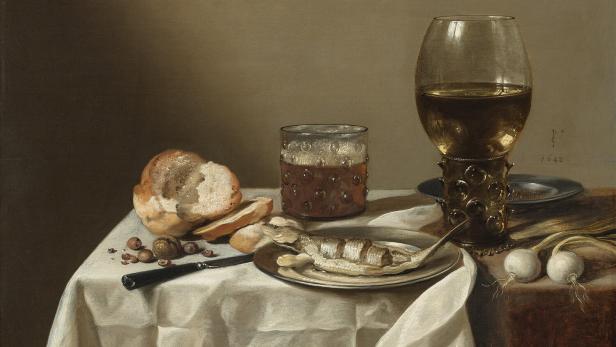 Stillleben von Pieter Claesz mit Fisch, Brot, Nüssen und Getränken auf einem Tisch.