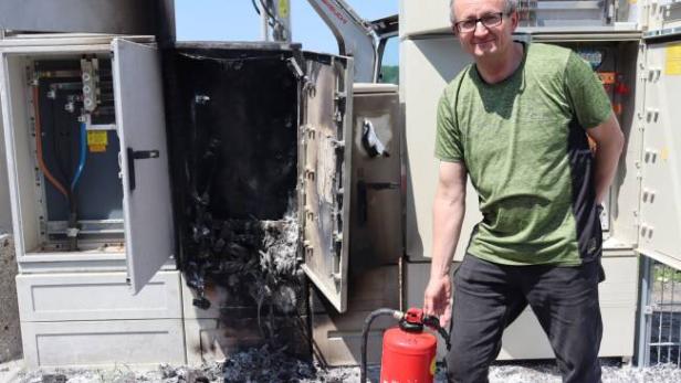 Thomas Scherzer steht mit einem Feuerlöscher an der Brandstelle.