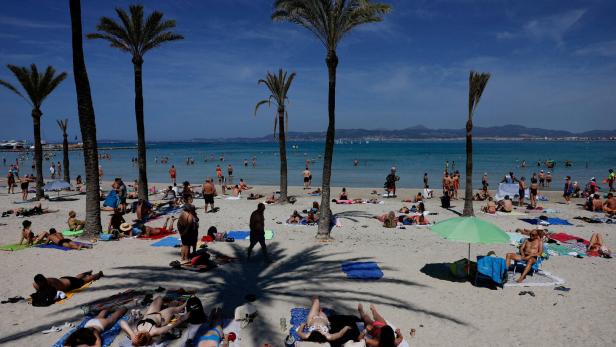 Tourists sunbathe in El Arenal beach in the island of Mallorca