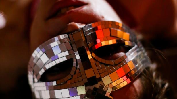 Eine Person liegt mit einer verspiegelten Maske auf dem Gesicht da.