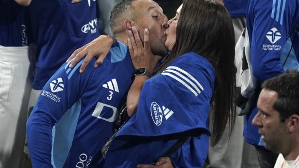 Ein Mann im blauen Trikot von Real Oviedo küsst eine Frau.