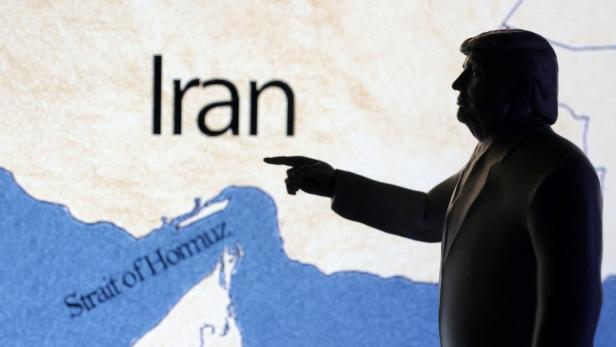 Illustration shows map showing the Strait of Hormuz, Iran and 3D printed miniature of U.S. president Donald Trump