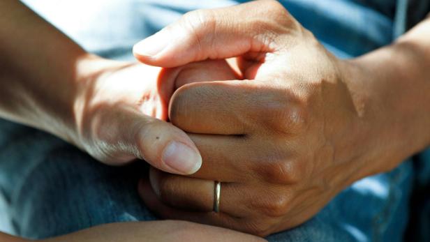 Hände Frau und Mann halten sich an der Hand