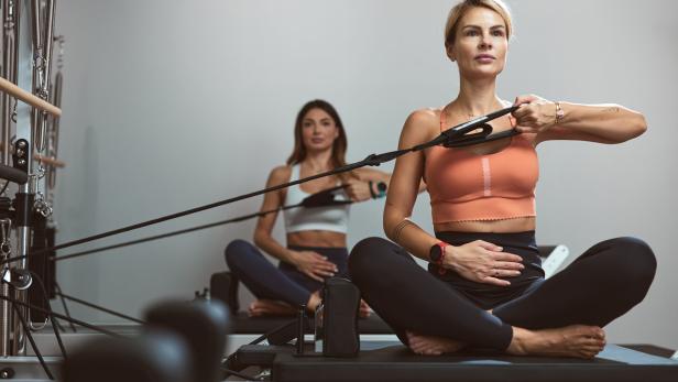 Zwei junge Frauen beim Reformer Pilates