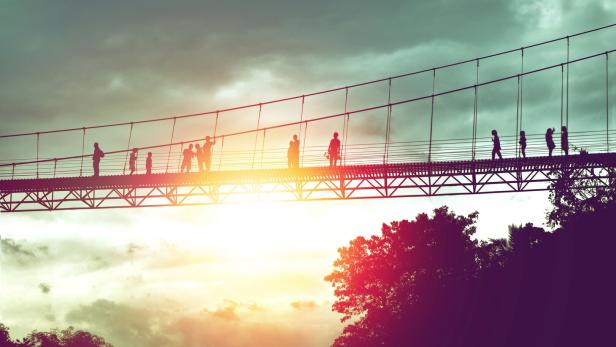 silhouette of tourist on suspension bridge walkway to the jungle in Surat Thani provine Thailand.