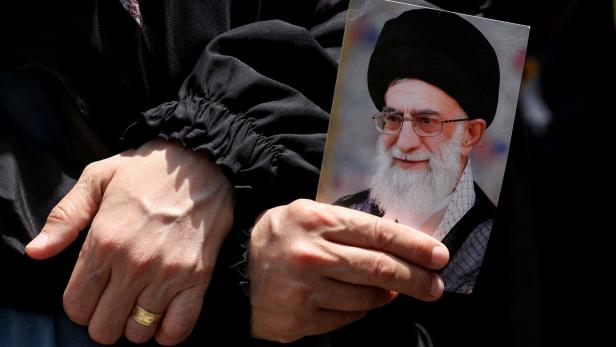 A demonstrator holds a picture of Iran's Supreme Leader Ayatollah Ali Khamenei as people gather for a rally in solidarity with Iran after Friday prayers, amid the Iran-Israel conflict, in Beirut's southern suburbs