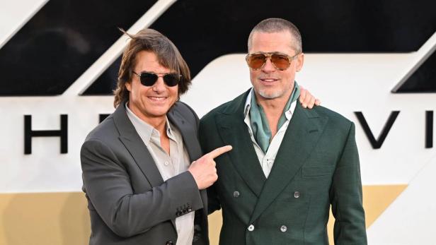 Tom Cruise und Brad Pitt posieren zusammen auf einem Foto.
