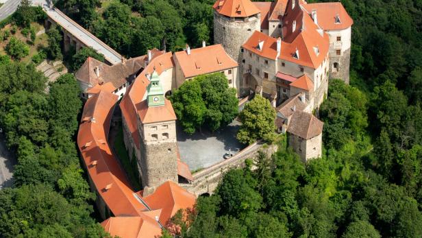 Luftaufnahme der Burg Forchtenstein, umgeben von dichtem Grün.