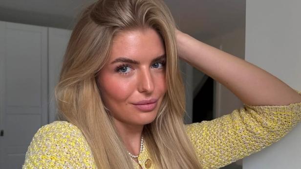 Antonia Hemmer posiert in gelber Strickjacke für ein Selfie